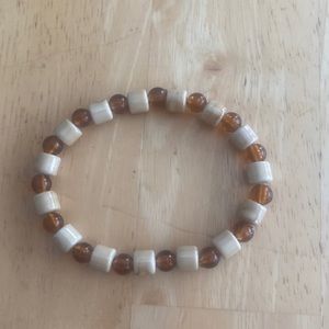 Tan and orangish brown stretch plastic bead bracelet. See pic for size.